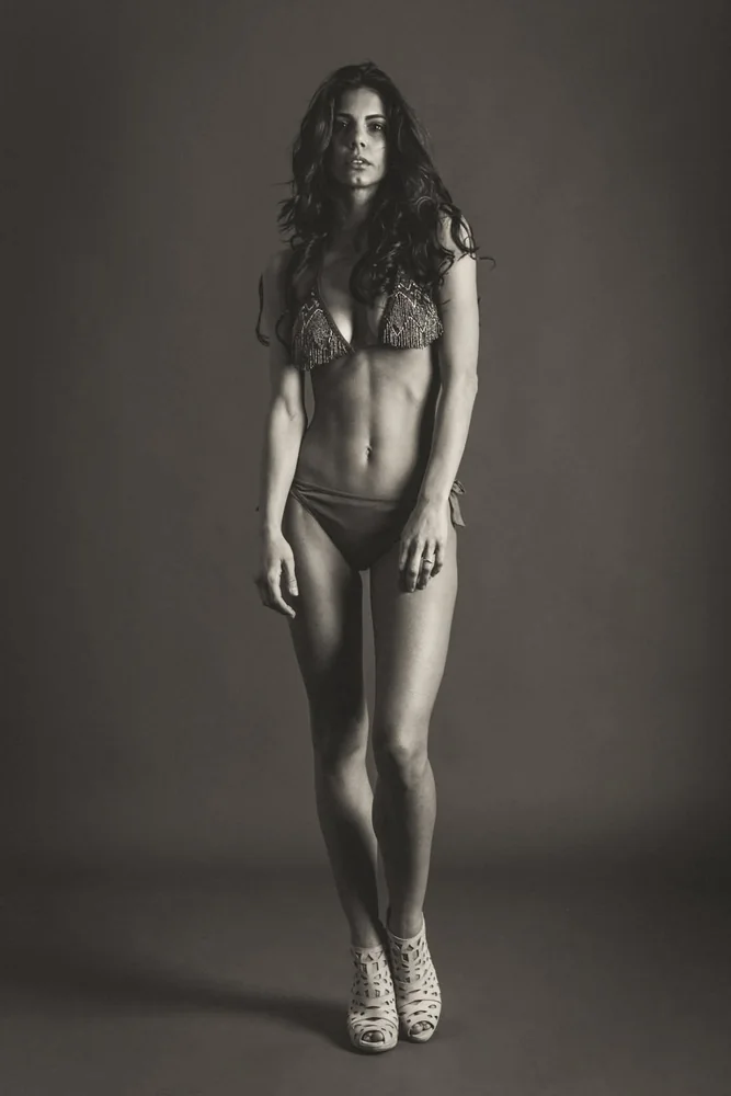 Modella in costume e tacchi in studio, fotografia a figura intera in bianco e nero