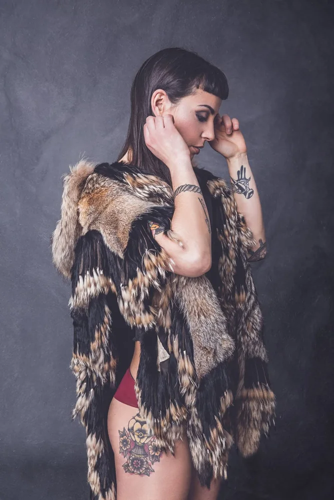 Ritratto editoriale in studio, modella di profilo con texture e dettagli di abbigliamento