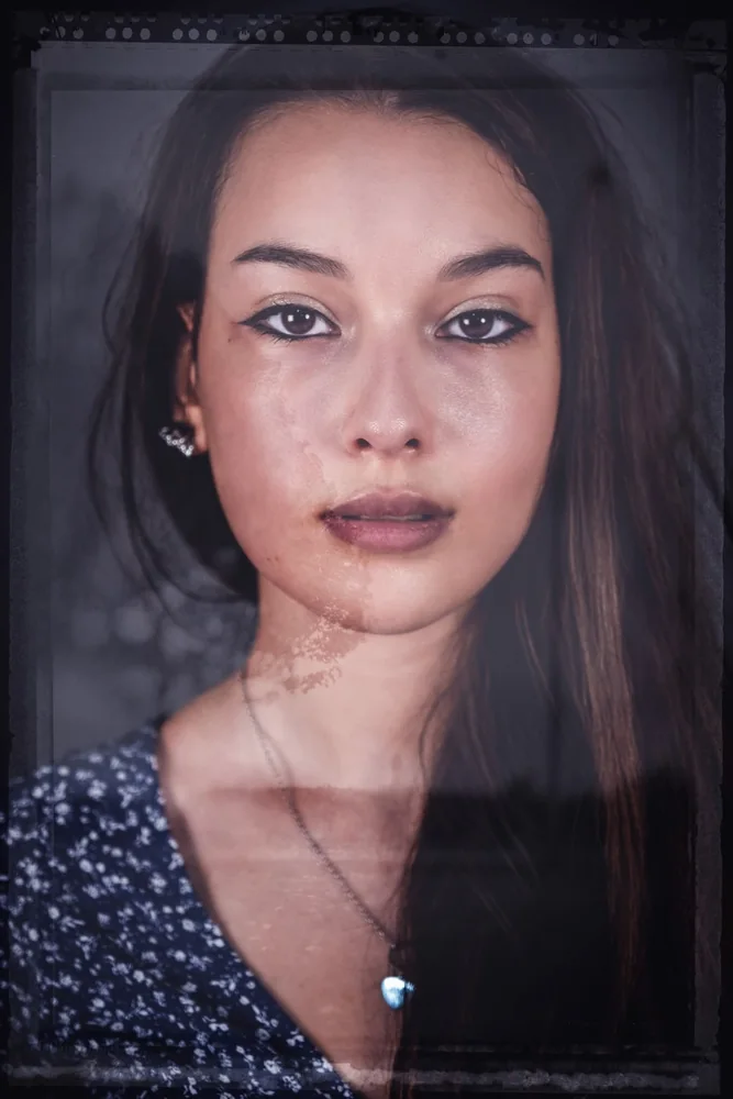 Ritratto femminile frontale con capelli scuri e cornice fotografica dall’effetto pellicola